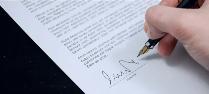 Pessoa assinando um contrato.