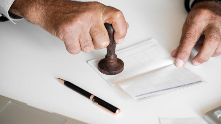 Pessoa assinando documentos para Averbação de imóveis.