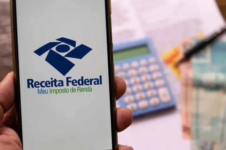 Celular com aplicativo da Receita Federal aberto na tela.