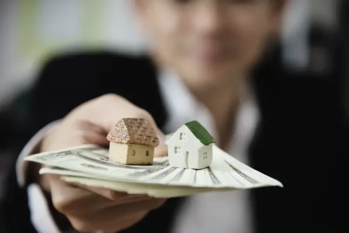 Pessoa segurando dinheiro para compra de imóvel.