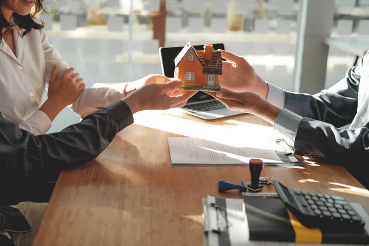 Consultor imobiliário orientando investidores com documentos.